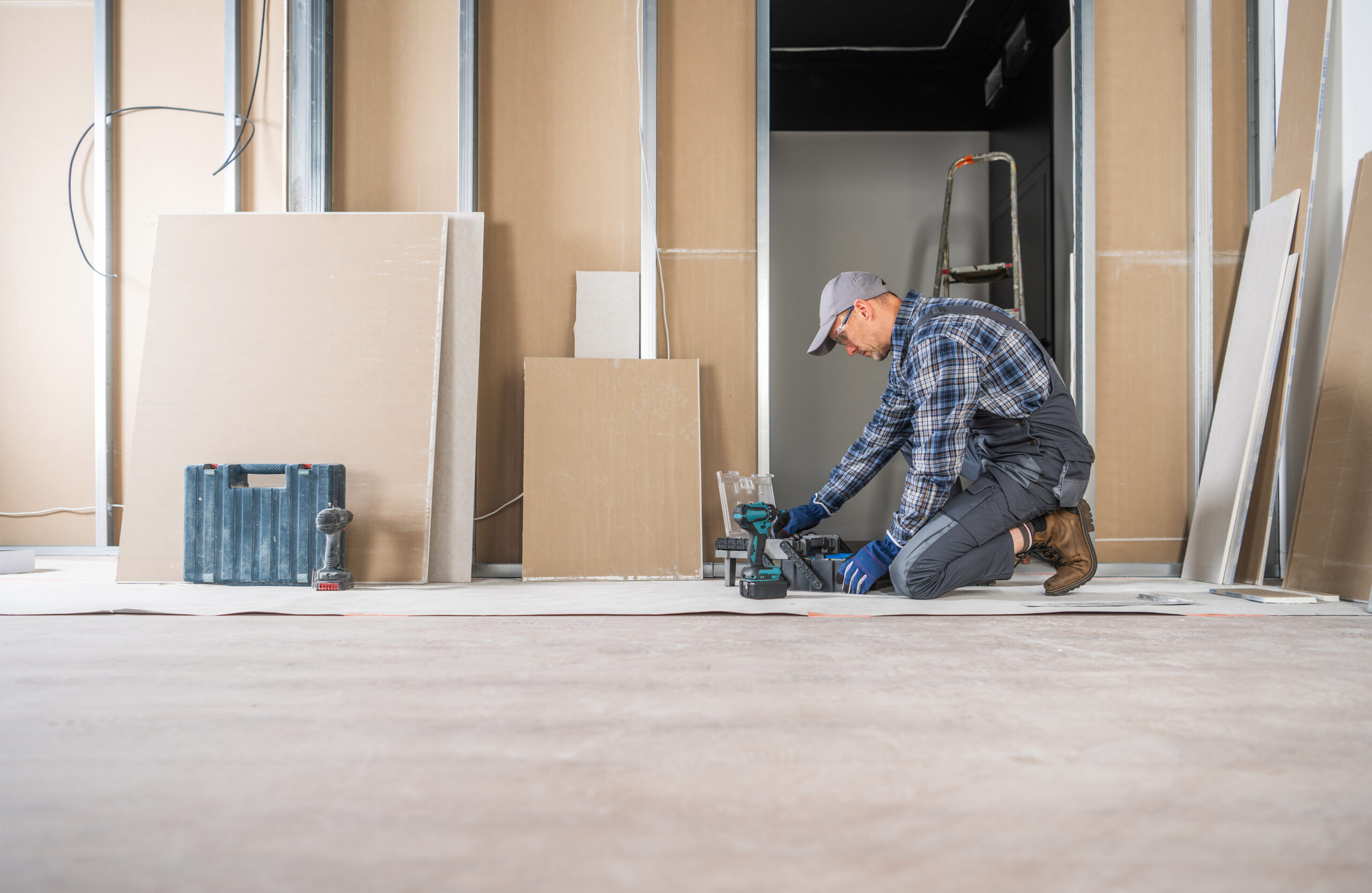 Caucasian Contractor Looking For the Right Tools Inside His Toolbox. Interiors Finishing