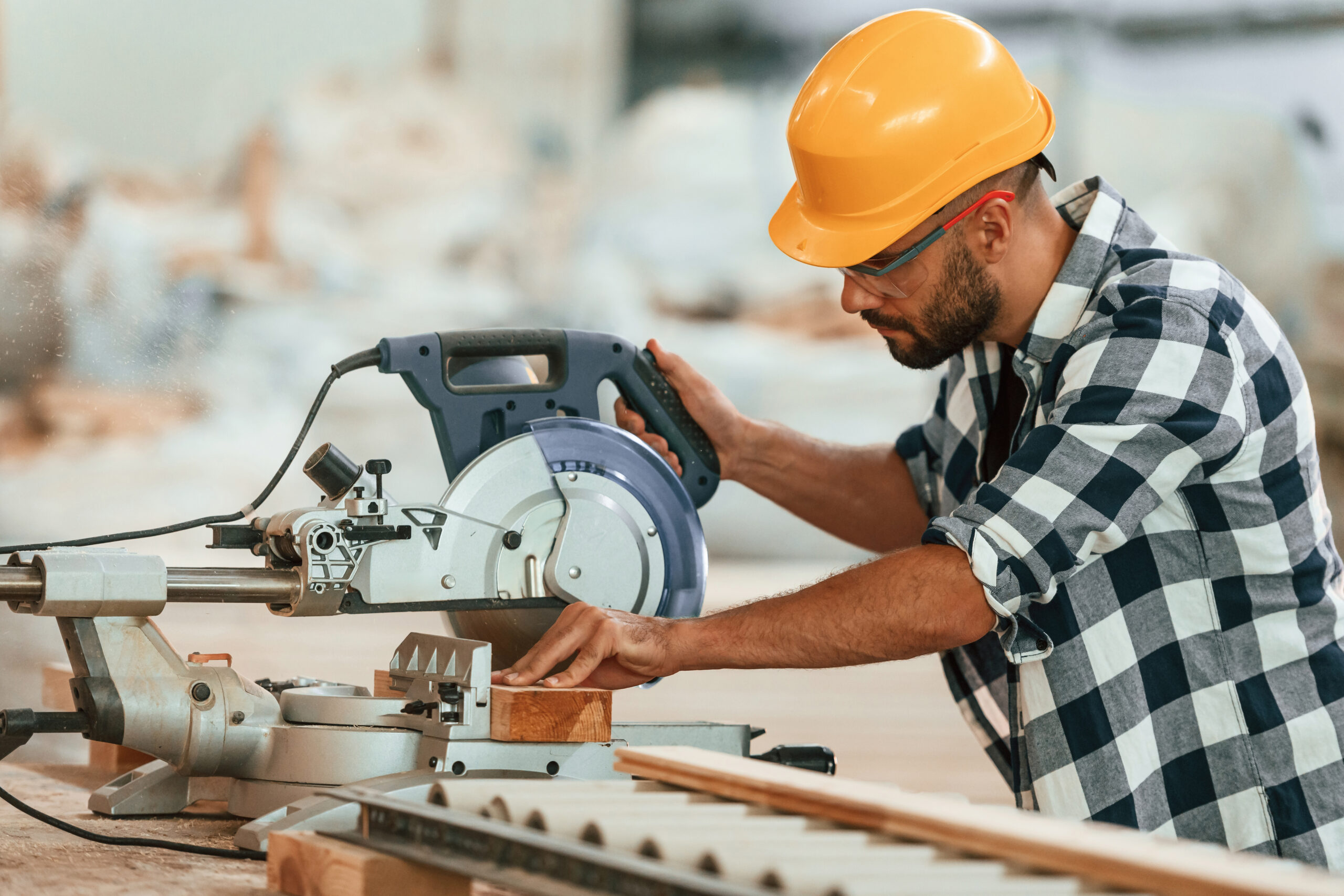Cutting the wood. Industrial worker in the warehouse.