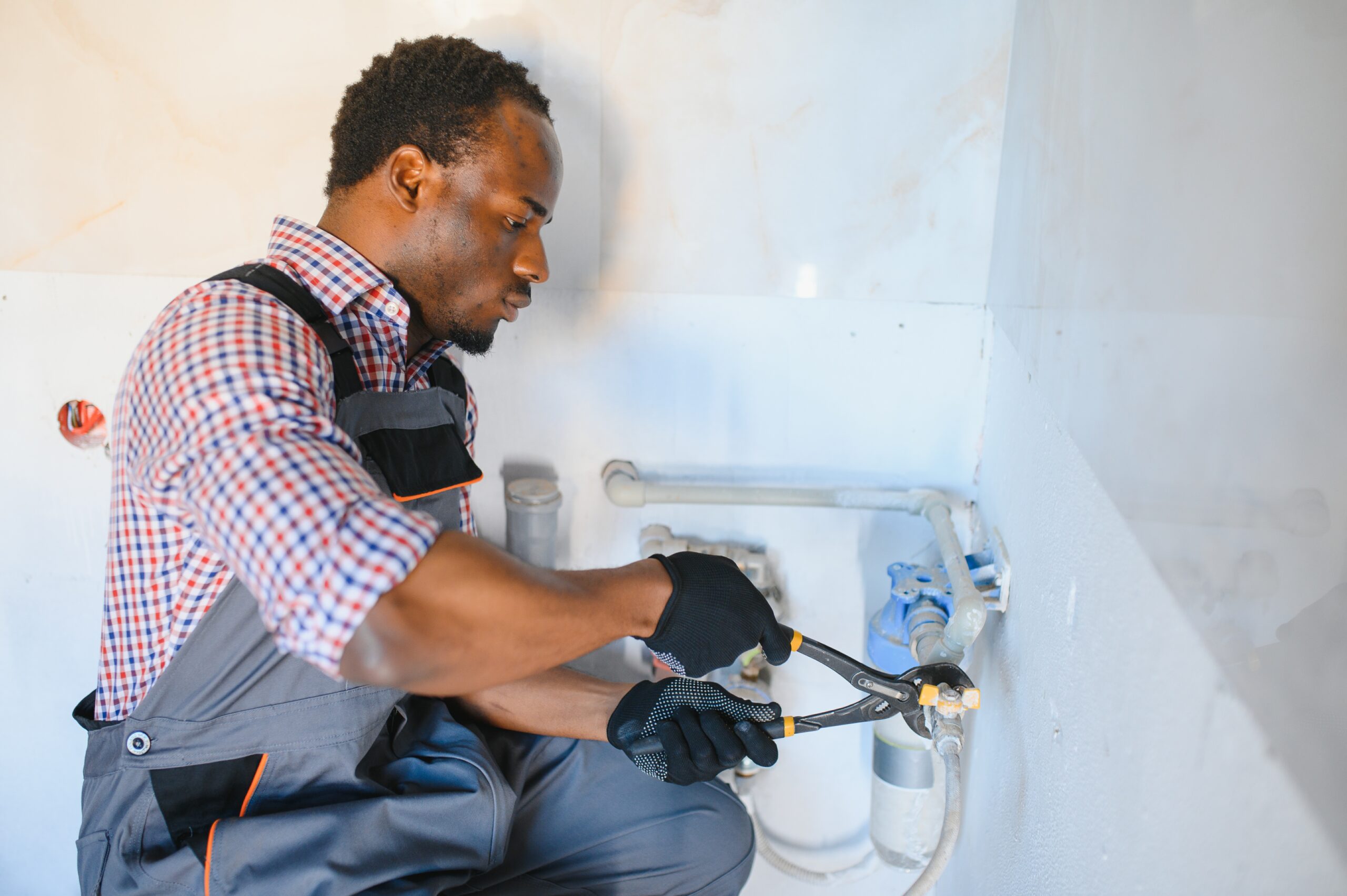 African American Plumber installs or change water filter. Replacement aqua filter.