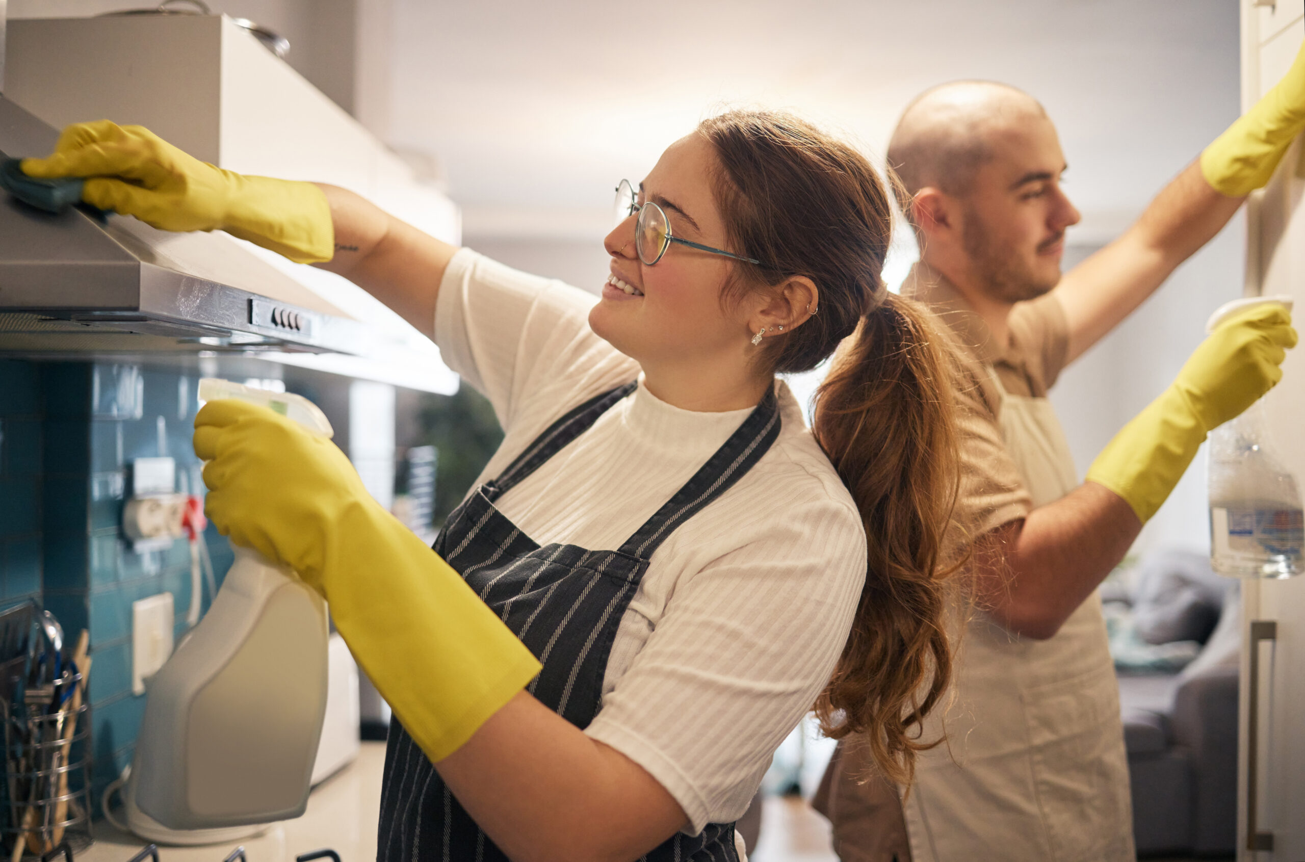 Saturdays are for spring cleaning together. Shot of a young couple cleaning their kitchen together